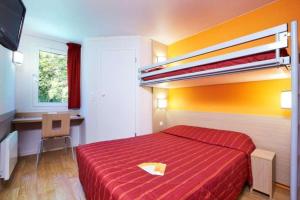 a bedroom with a bed with a red bedspread at Premiere Classe Tours Sud - Joue Les Tours in Joué-lès-Tours