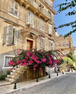 a building with pink flowers in front of it at Corfu Airport Flat in Corfu Town