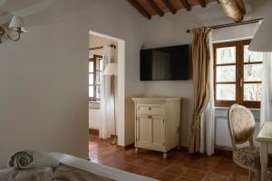 sypialnia z łóżkiem i telewizorem na ścianie w obiekcie Castello di Leonina Relais - Adults Only w Sienie