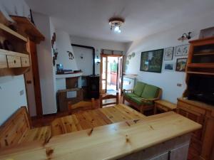 cocina y sala de estar con mesa de madera en Mimosa en Tagliacozzo