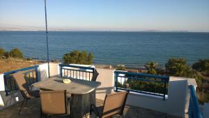 a table and chairs on a balcony overlooking the ocean at Galazio Kyma in Agios Ioannis