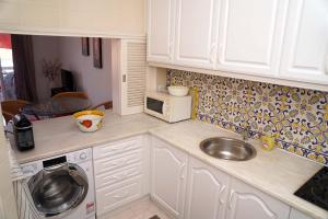 a kitchen with a sink and a washing machine at 2 bedroom apartment in Vale do Lobo in Vale do Lobo