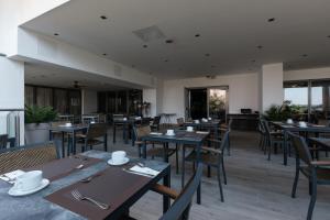a restaurant with wooden tables and chairs and windows at Eurostars Queen of Montenegro in Budva