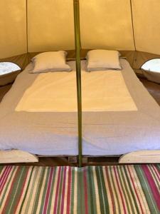 a pair of twin beds in a tent at 't Schaaphof Tent en Ontbijt in Deinze