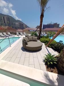 a patio with a couch next to a pool at NEW-Studio Apartments in EuroCity-Large Pool-Rock or Sea Views-Balcony-Free Parking-Holiday and Short Let Apartments in Gibraltar in Gibraltar