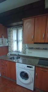 a kitchen with a washing machine and a sink at Apartamentos Caloca in Caloca