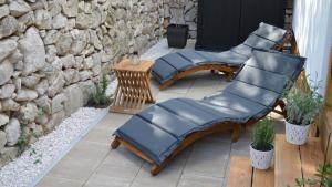 two chairs on a patio with a stone wall at Lucas Mobile Home - premium mobile home with terrace and patio in Drage