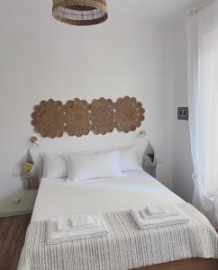 a bedroom with a white bed with a wooden headboard at Casa Amapola in Follonica