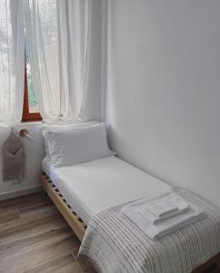 a small bed in a room with a window at Casa Amapola in Follonica