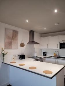 une cuisine avec des placards blancs et un comptoir blanc dans l'établissement Amazing London 1 BR Flat in Astral House AS18, à Norbury