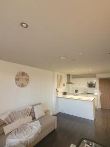 ein Wohnzimmer mit einem Sofa und einer Küche in der Unterkunft Amazing London 1 BR Flat in Astral House AS18 in Norbury