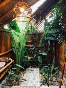 a greenhouse with plants and a light fixture at Tongo Hill Cottages in Moalboal