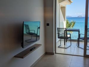 a living room with a tv and a balcony with the ocean at Panorama Inn in Lithakia