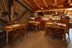 un comedor con mesas de madera y un bar en Chalet Faure en Sauze dʼOulx