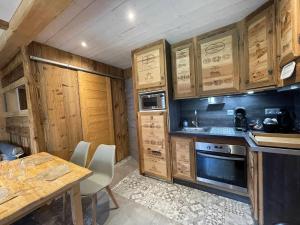 a kitchen with wooden cabinets and a wooden table and a table and a tablektop at Appartement Samoëns, 3 pièces, 4 personnes - FR-1-624-85 in Samoëns