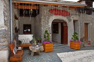 an outdoor patio with potted plants and a table at Chalet Faure in Sauze dʼOulx