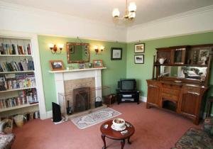 a living room with a fireplace and a tv at Cluny Mains in Newtonmore