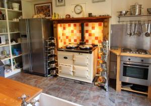 uma cozinha com electrodomésticos de aço inoxidável num quarto em Cluny Mains em Newtonmore