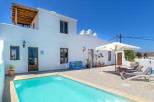 a villa with a swimming pool in front of a house at Casa El Patio Teseguite in Teseguite