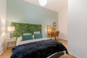 1 dormitorio con 1 cama grande y pared verde en Le Tropical de Lamartine, en Limoges
