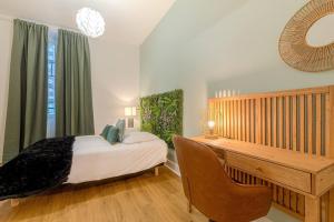 1 dormitorio con cama y escritorio de madera en Le Tropical de Lamartine en Limoges