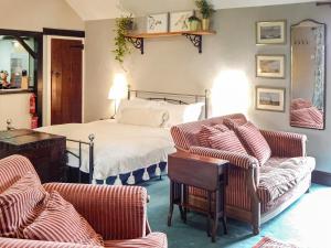 a bedroom with a bed and two chairs at The Drake Studio in Chipping Sodbury