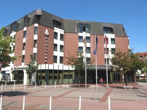 a large brick building with benches in front of it at Hotel Panorama Hamburg-Harburg in Hamburg