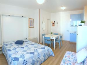 ein Schlafzimmer mit einem Bett und einem Tisch sowie eine Küche in der Unterkunft Apartment in Bibione with balcony in Bibione