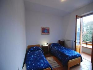 ein Wohnzimmer mit 2 Betten und einem Fenster in der Unterkunft Il Boschetto in Le Grazie