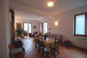 ein Esszimmer mit einem Tisch und Stühlen im Wohnzimmer in der Unterkunft Il Boschetto in Le Grazie