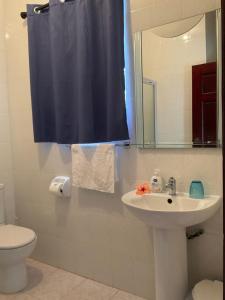 uma casa de banho com um lavatório, um WC e um espelho. em Le Chevalier Bay Guesthouse em Anse Lazio