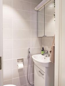 a white bathroom with a sink and a shower at 2ndhomes Tampere "Hämeenkatu" Apartment - Renovated Apt in a Historical Building in Tampere