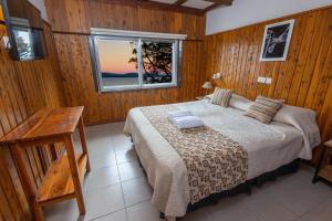 um quarto com uma cama e uma janela em Tierra Gaucha Hostel Boutique em San Carlos de Bariloche