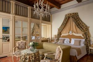 a bedroom with a bed and a couch and a chandelier at Castello di Leonina Adults Only in Casetta
