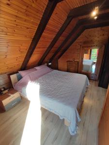 een slaapkamer met een groot bed op zolder bij Kuća za odmor Šum slapa in Karlovac