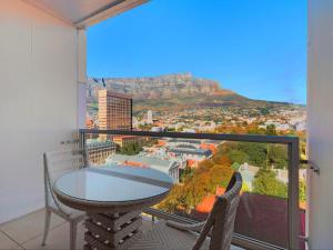 a table and two chairs on a balcony with a view at Taj 2 bed Suite - deluxe hotel suite with lounge & stunning Table Mtn views in Cape Town