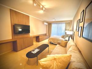 ブエノスアイレスにあるLuxury Apartments in Deco Recoleta by Apartments Barilocheのリビングルーム(ソファ、テレビ、ベッド付)