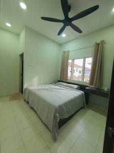 una camera con letto e ventilatore a soffitto di Tanjong Karang,(10minutes to sekinchan) Semi D/up to 14 pax+ a Tanjung Karang