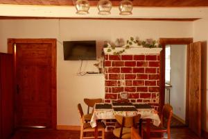 a dining room with a table and a brick wall at Agroturystyka u Koziołka in Długowola