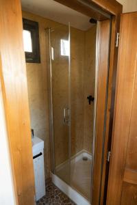 a shower with a glass door in a bathroom at maringotka k pronájmu 
