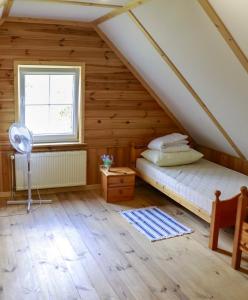 sypialnia z łóżkiem i oknem na poddaszu w obiekcie Agroturystyka u Koziołka w mieście Długowola