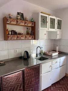 a kitchen with white cabinets and a sink at Agroturystyka u Koziołka in Długowola