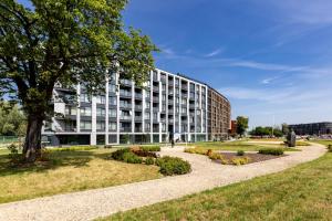 a building with a park in front of it at Downtown Apartments Chlebova Riverside - Parking & Gym in Gdańsk