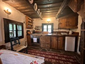 a kitchen with wooden cabinets and a stove top oven at The Village Pension in Breb