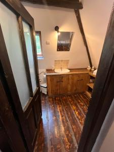 a bathroom with a sink and a wooden floor at The Village Pension in Breb +53 photos