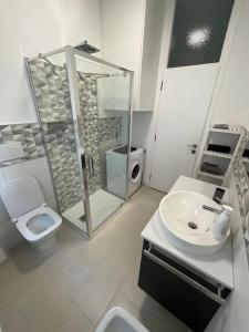 een badkamer met een wastafel, een douche en een toilet bij Green House Calolziocorte in Calolziocorte