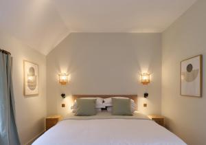 a bedroom with a large white bed with two lamps at Castle Hill Cottage in Crowborough