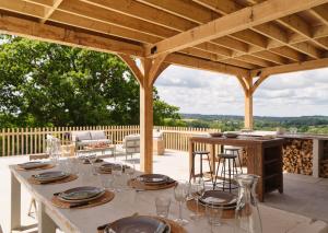 a table set up for a meal under a wooden pergola at Castle Hill Cottage in Crowborough
