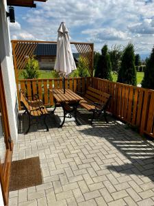 a patio with a picnic table and an umbrella at Orawski Letniskowiec in Zubrzyca Dolna