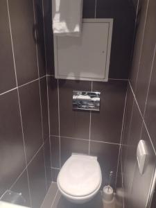 a bathroom with a white toilet in a stall at Hôtel Tingis in Paris